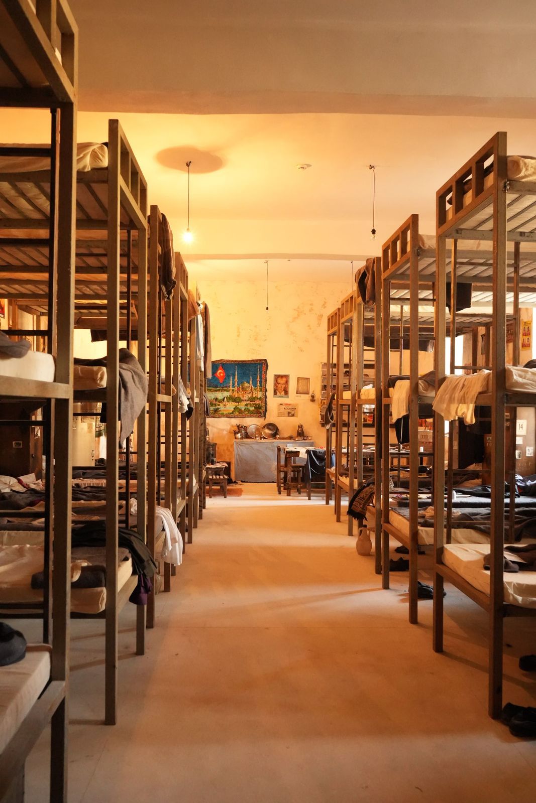 Warmly lit dormitory with rustic wooden bunk beds, typical of pilgrim albergue accommodation
