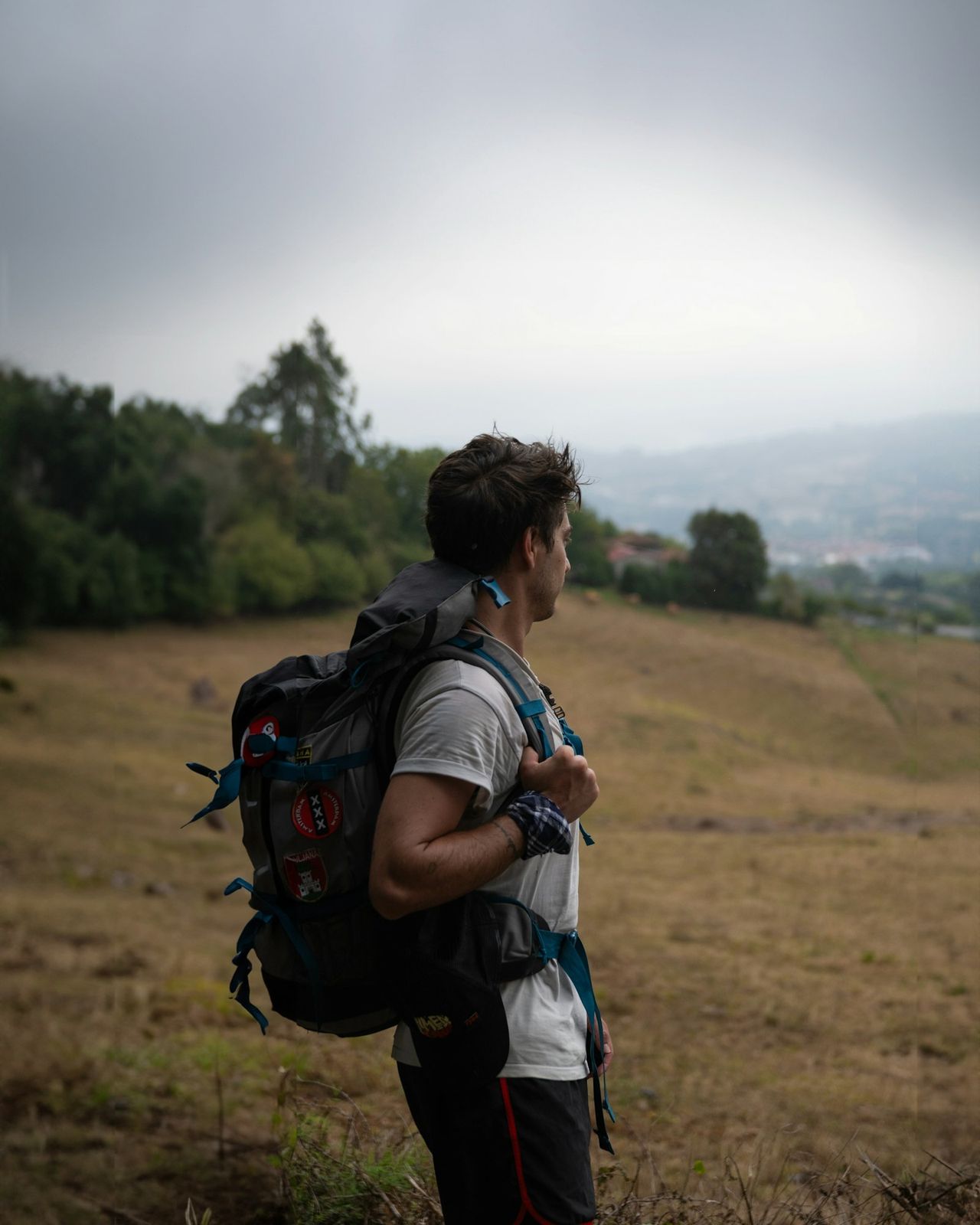 Lone pilgrim with a backpack walking the Camino de Santiago through open countryside