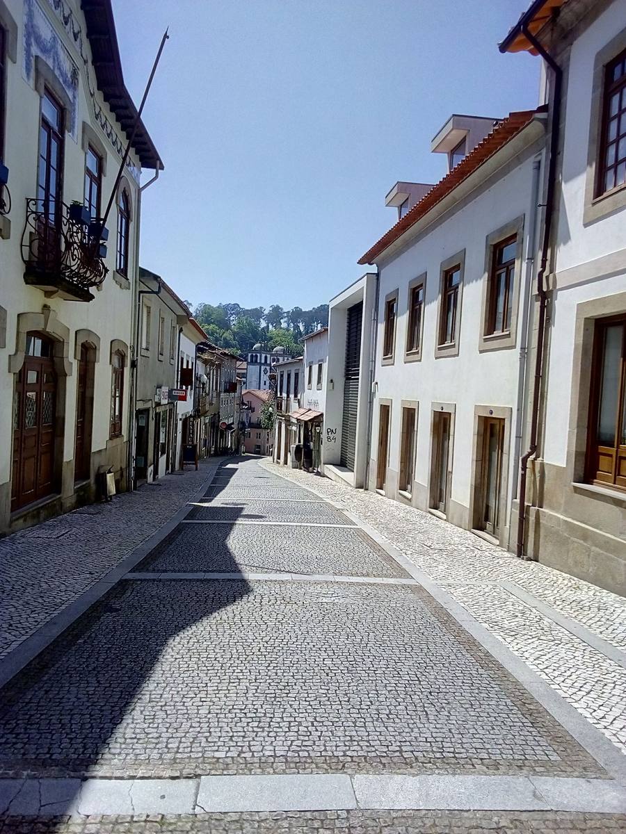 Cobblestone street lined with traditional Portuguese houses in Santa Maria da Feira, on the inland Central Camino corridor