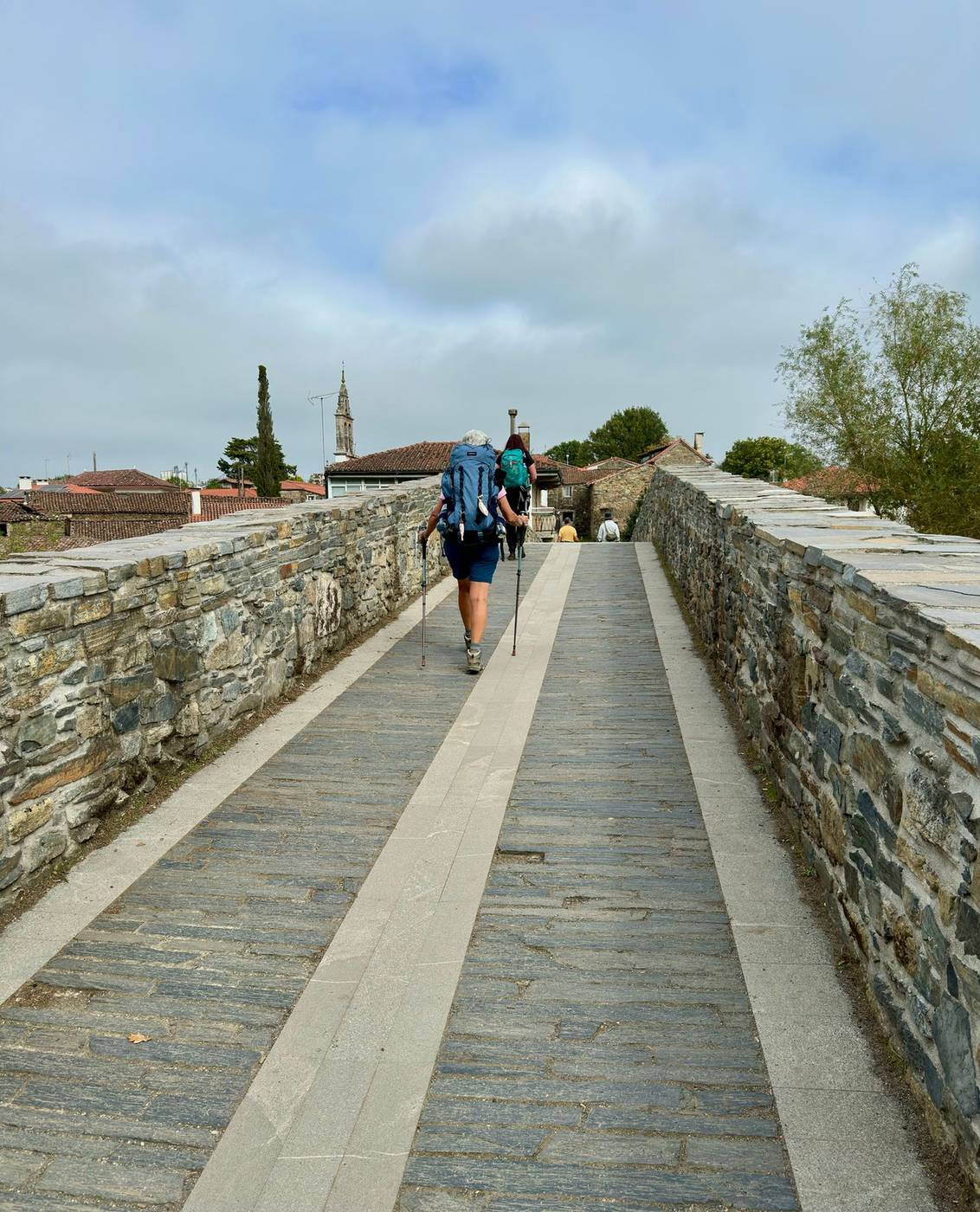 Pilgrims walking a stone path on the Camino Português