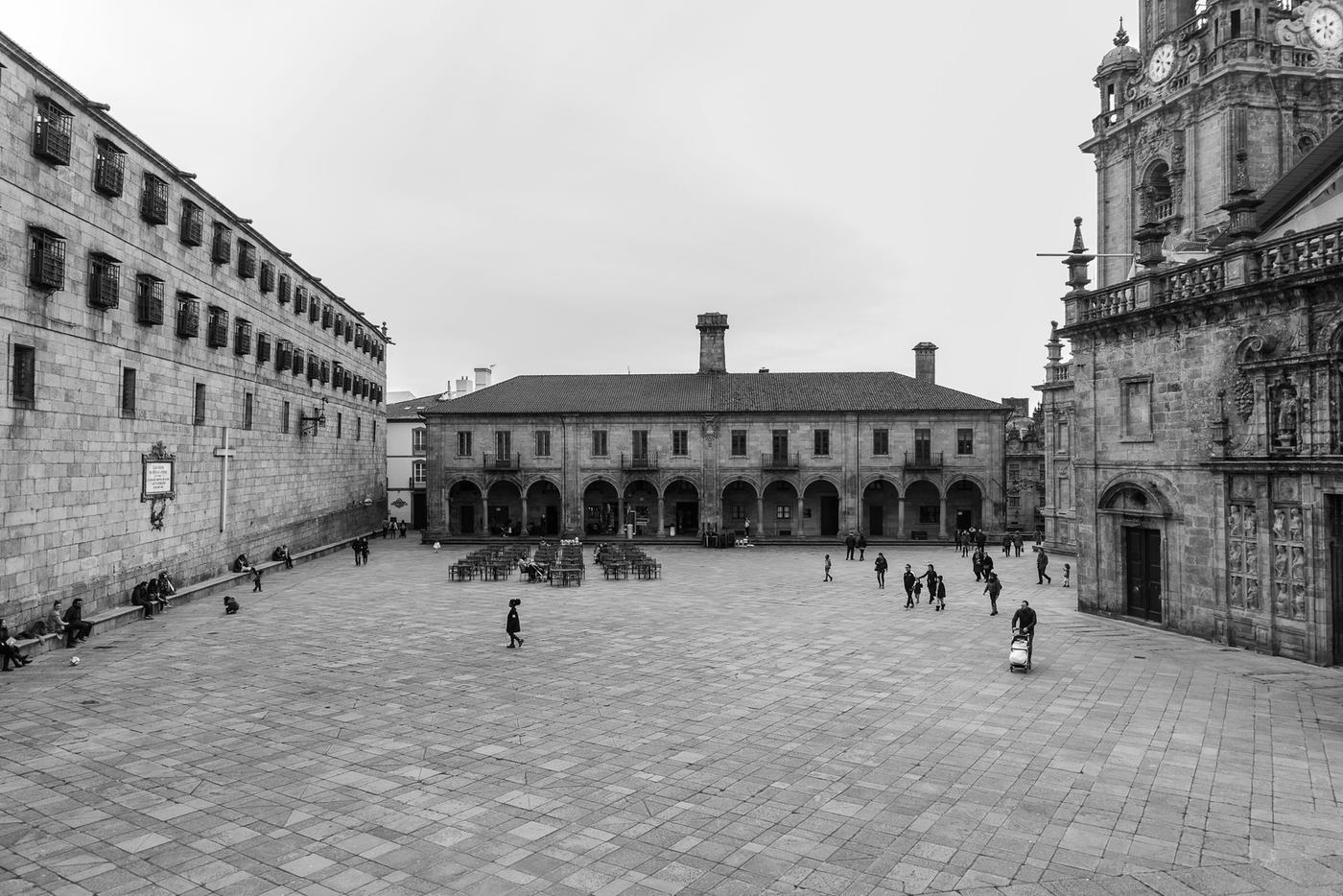 Walkers crossing a granite plaza in Santiago de Compostela after finishing the Camino